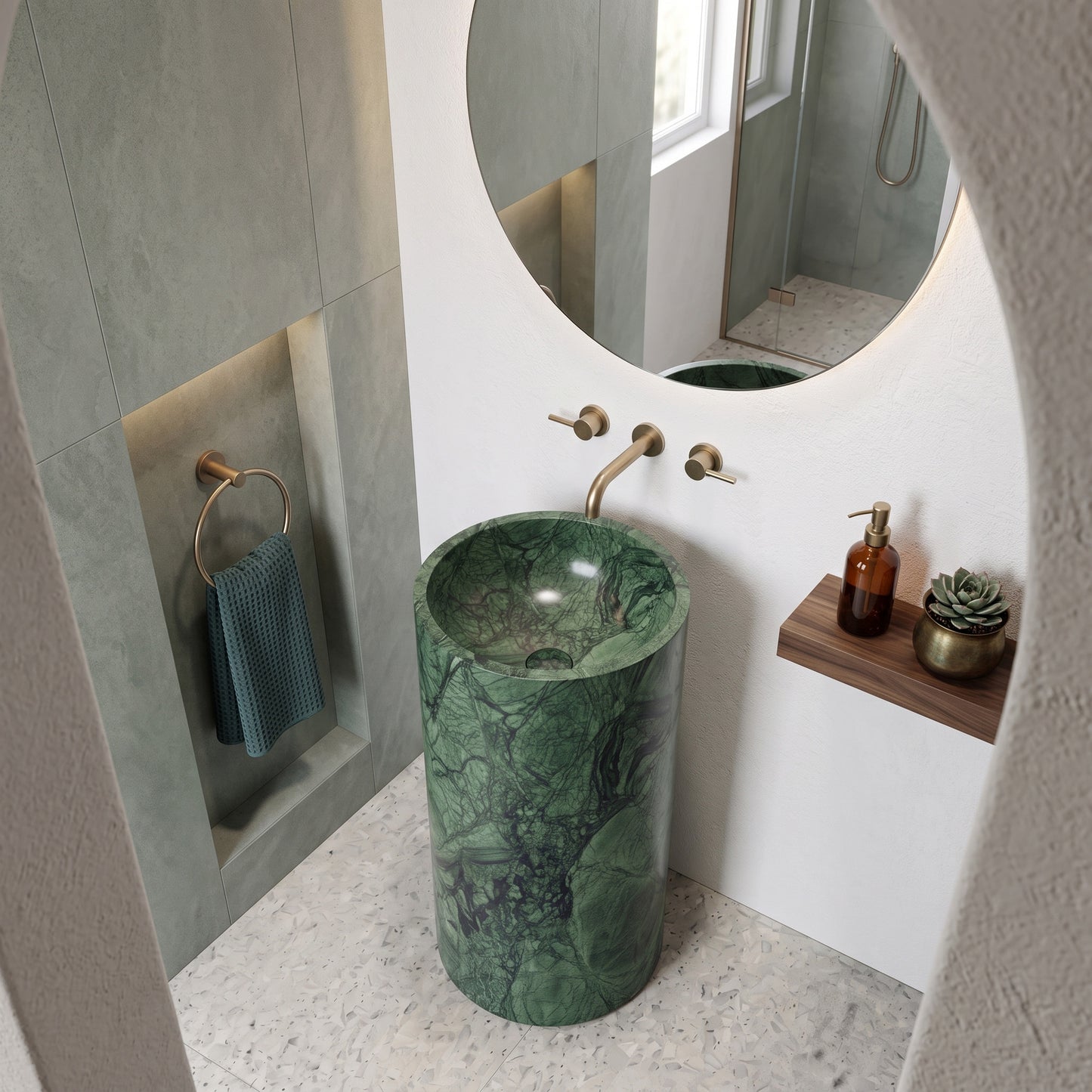 Freestanding Verde Guatemala marble round pedestal basin in a modern luxury bathroom featuring fluted sage wall paneling, terrazzo flooring, and black bathtub.