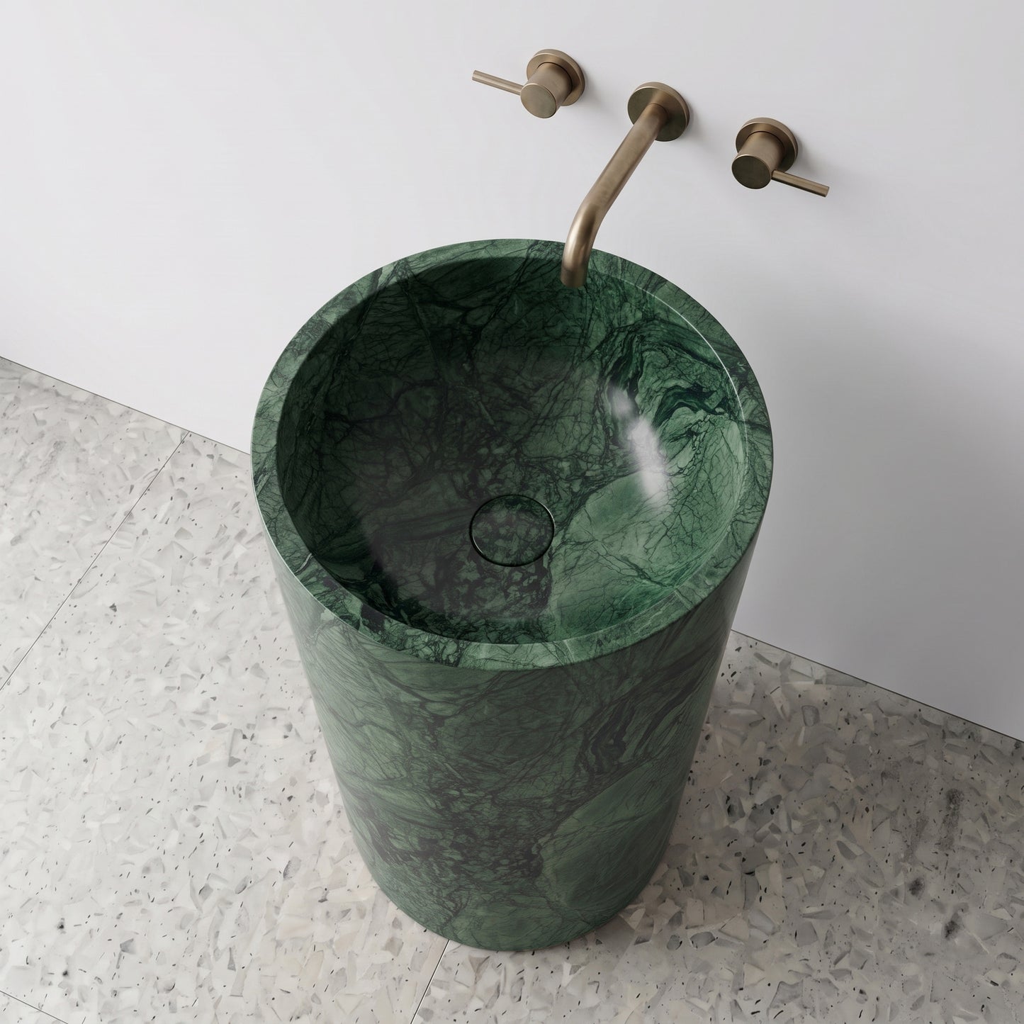 High-angle top view of a Green Guatemala cylindrical marble pedestal sink showing deep emerald webbing and matching integrated stone drain cap.