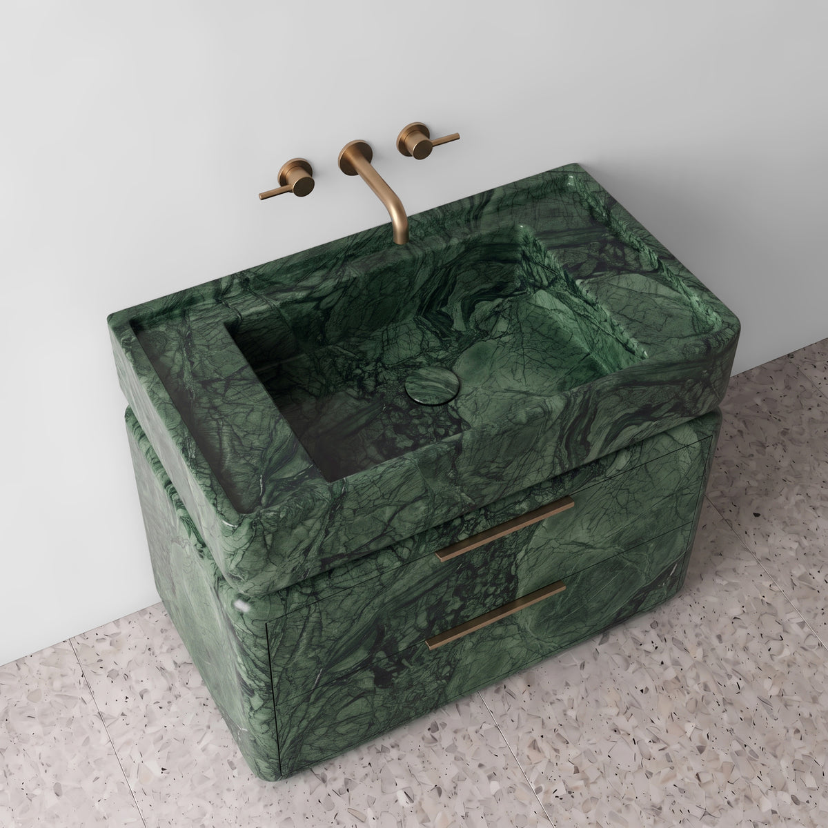 High-angle perspective view of the Green Guatemala marble double-drawer vanity, highlighting the integrated trough sink with a matching marble drain cover, raised perimeter border, curved drawer contours, brushed brass linear hardware, and rich verdant veining.