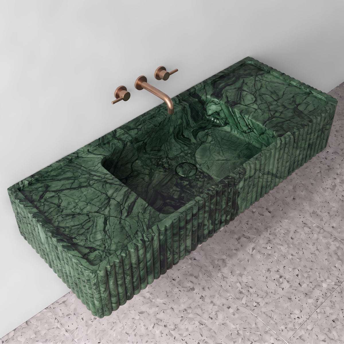 Elevated three-quarter angle of the Green Guatemala fluted monolith sink showing the integrated trough basin, matching stone drain cover, raised perimeter edge, and ribbed profile detailing.