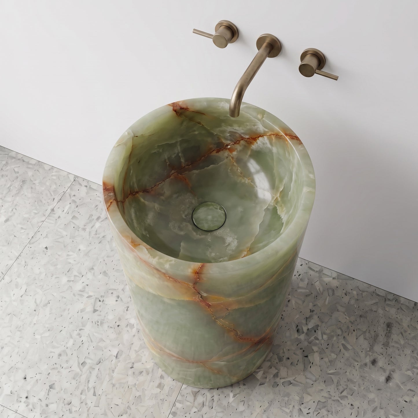 High-angle top view of a Green Onyx cylindrical gemstone sink highlighting semi-translucent crystal banding and matching integrated stone drain cap.