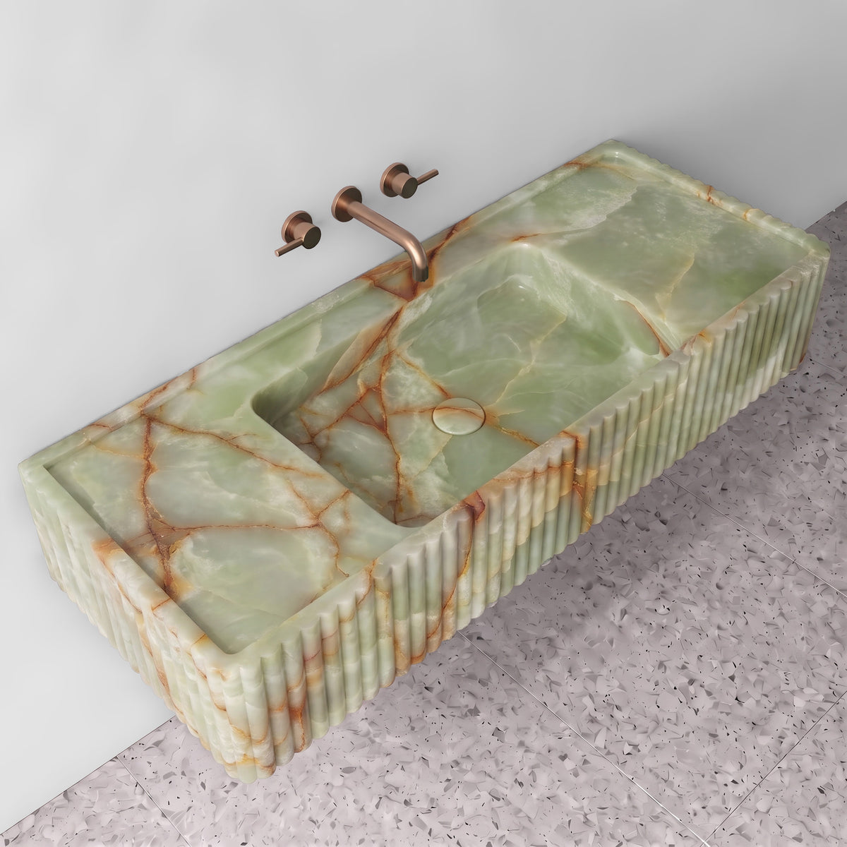 Elevated three-quarter angle of the Green Onyx fluted monolith sink showing the integrated trough basin, matching stone drain cover, raised perimeter lip, and ribbed profile detailing.