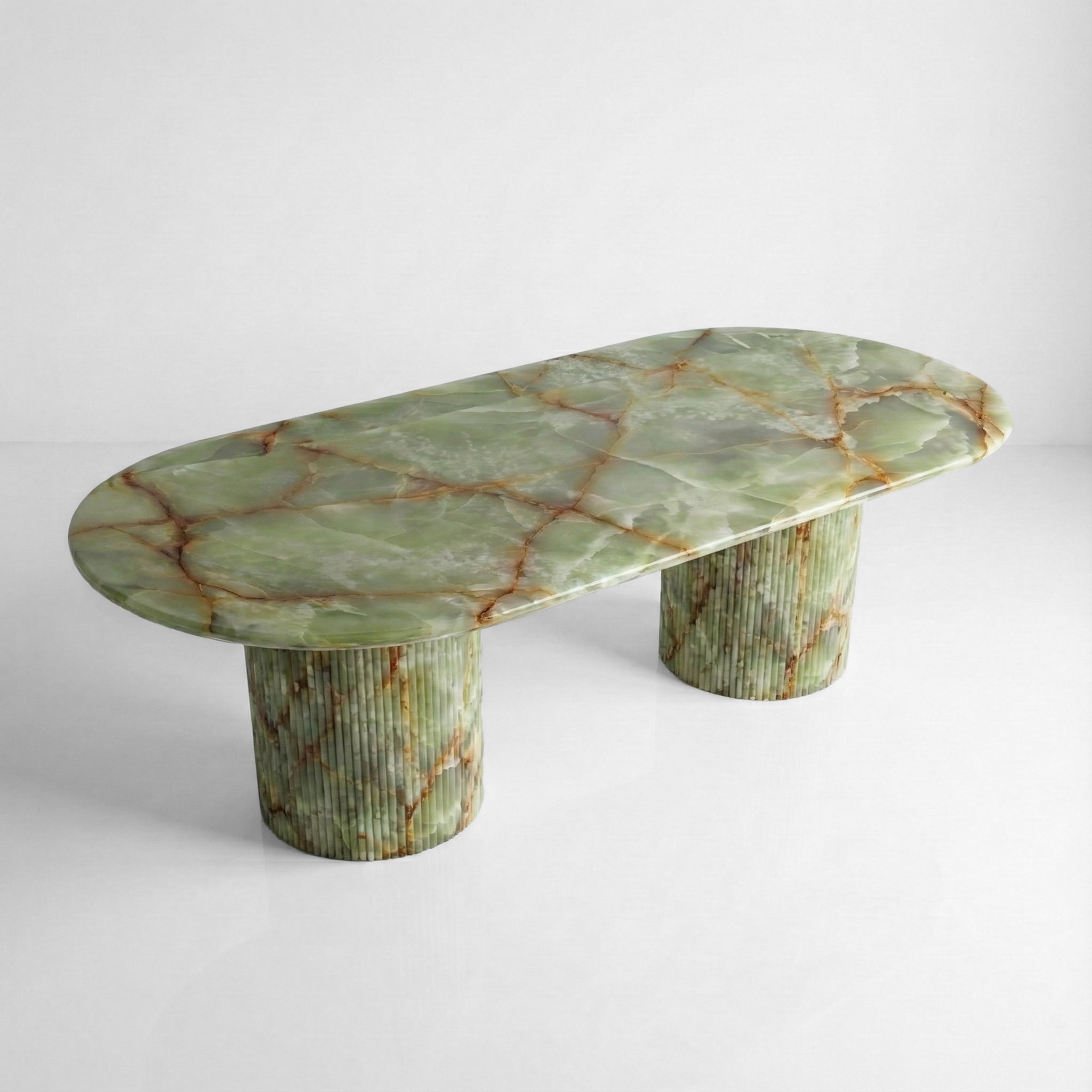 High-angle view of a large oval Green Onyx dining table, showcasing the semi-precious stone surface and its complex web of emerald and amber mineral patterns.