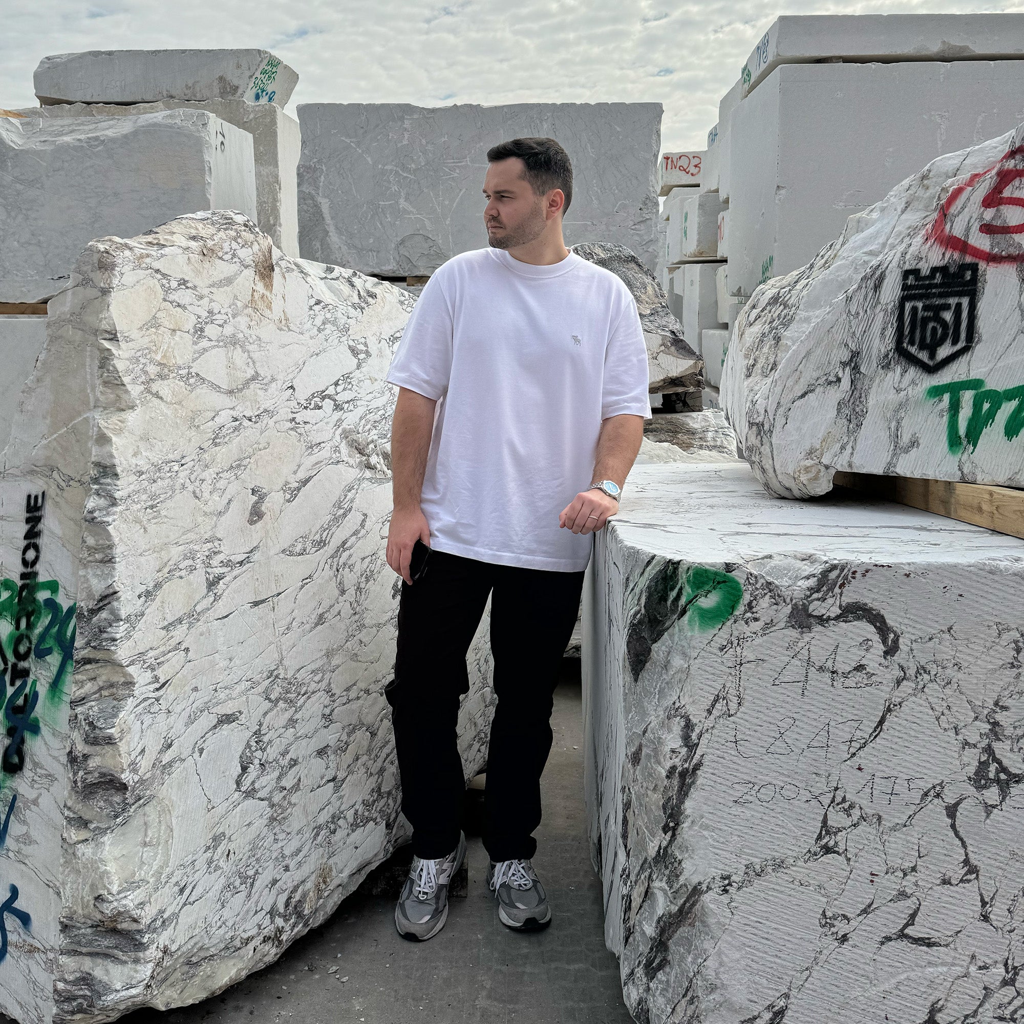 The founder of GustavDesign performing a quality inspection of massive marble slabs, ensuring the finest natural stone is sourced for custom luxury furniture.