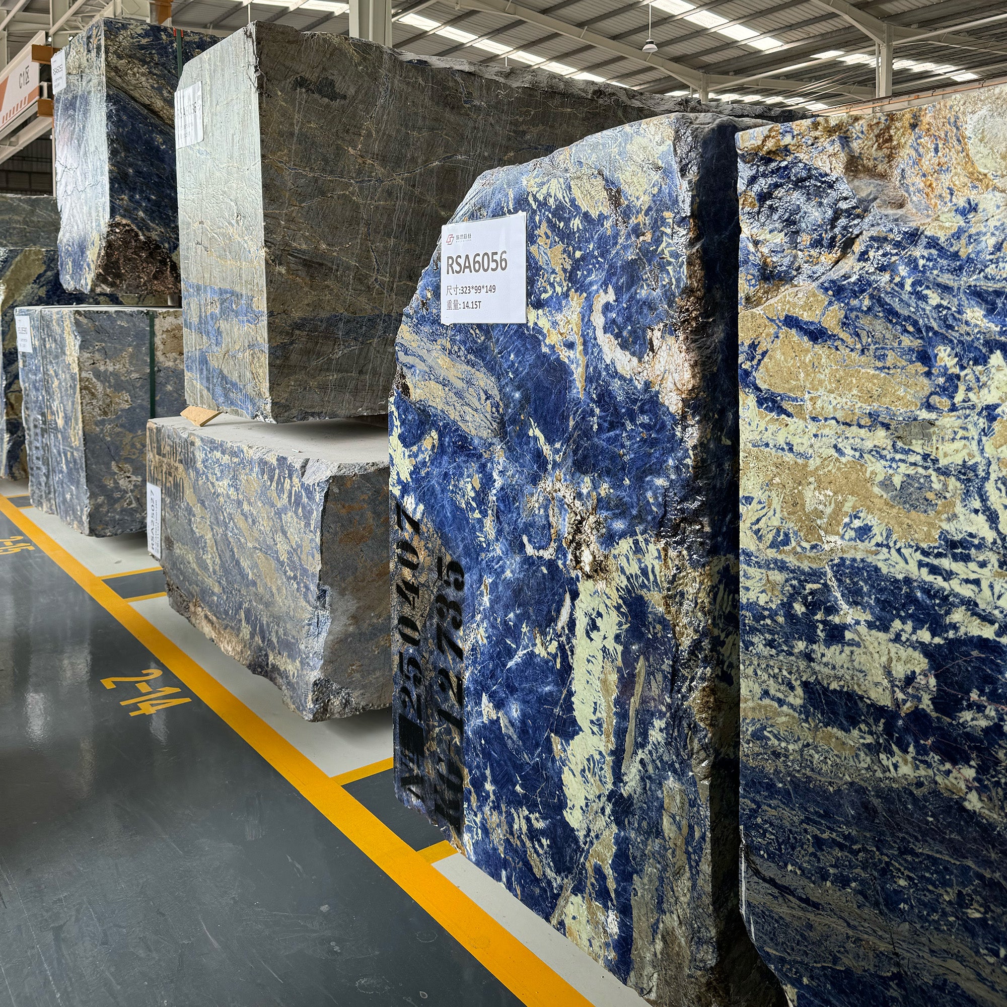Large raw Sodalite Blue marble blocks and luxury natural stone materials in a warehouse, ready for high-end custom furniture and architectural projects by GustavDesign.