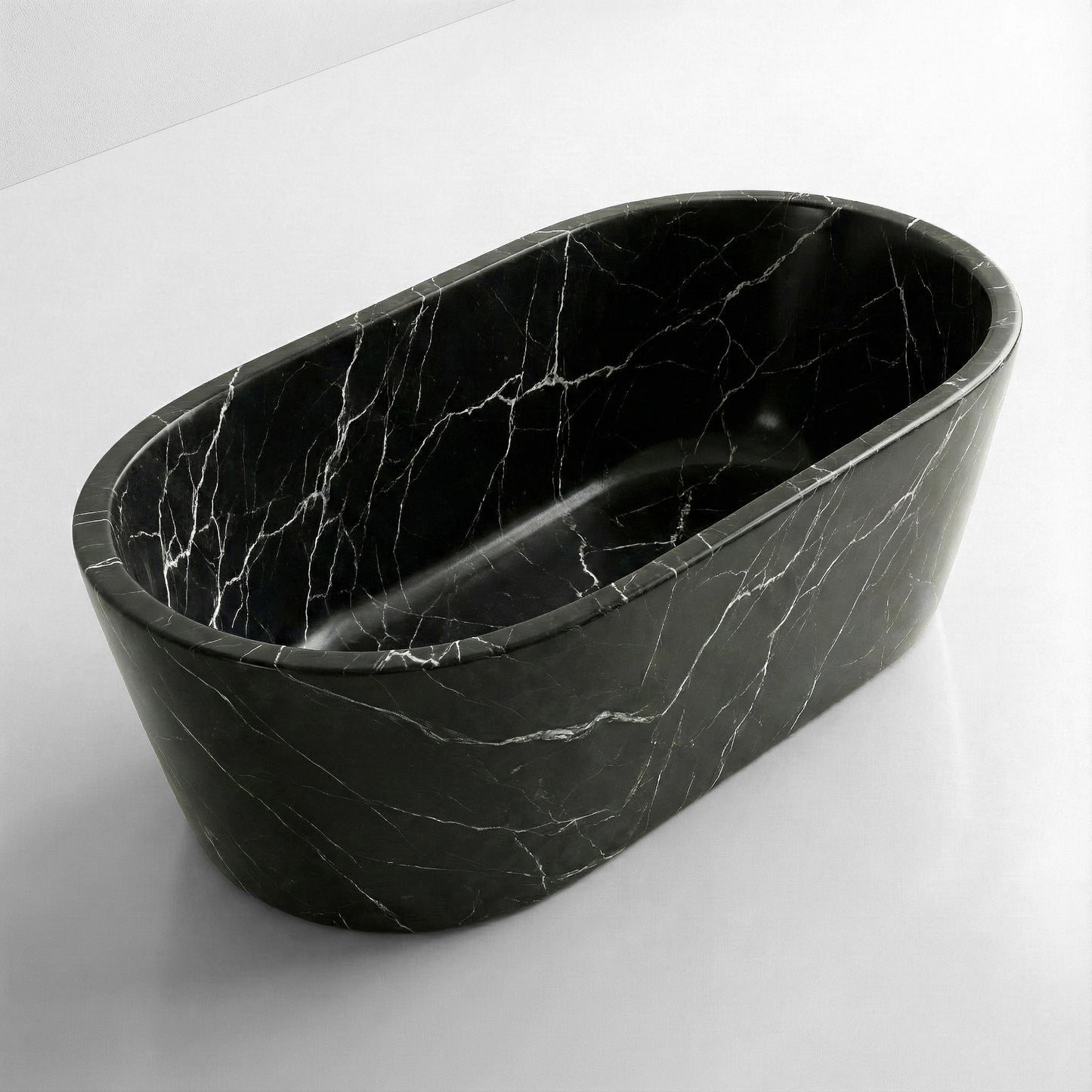 High-angle view of a freestanding oval Nero Marquina marble bathtub, featuring deep black stone with stark white veining and a polished finish.