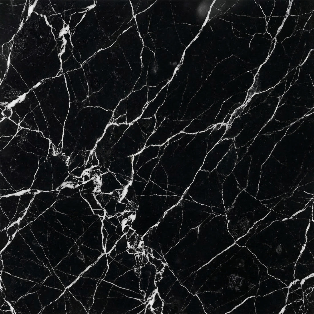 Nero Marquina black marble slab featuring striking, sharp white lightning-like veins for modern kitchen islands and vanity tops.