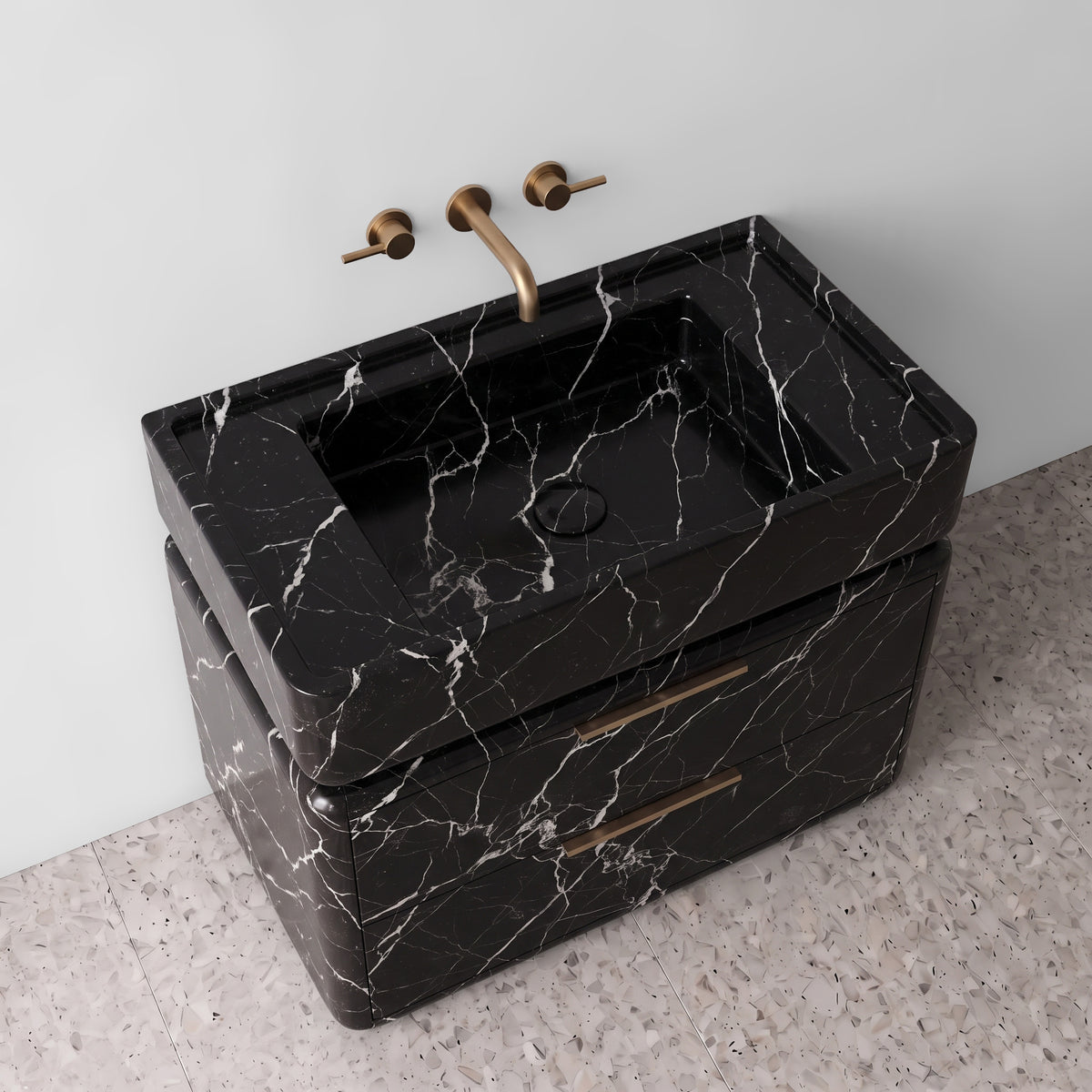 High-angle perspective view of the Nero Marquina marble double-drawer vanity, highlighting the integrated trough sink with a matching stone drain cover, raised perimeter border, rounded drawer corners, brushed brass linear pulls, and fine white calcite veining across polished black marble.