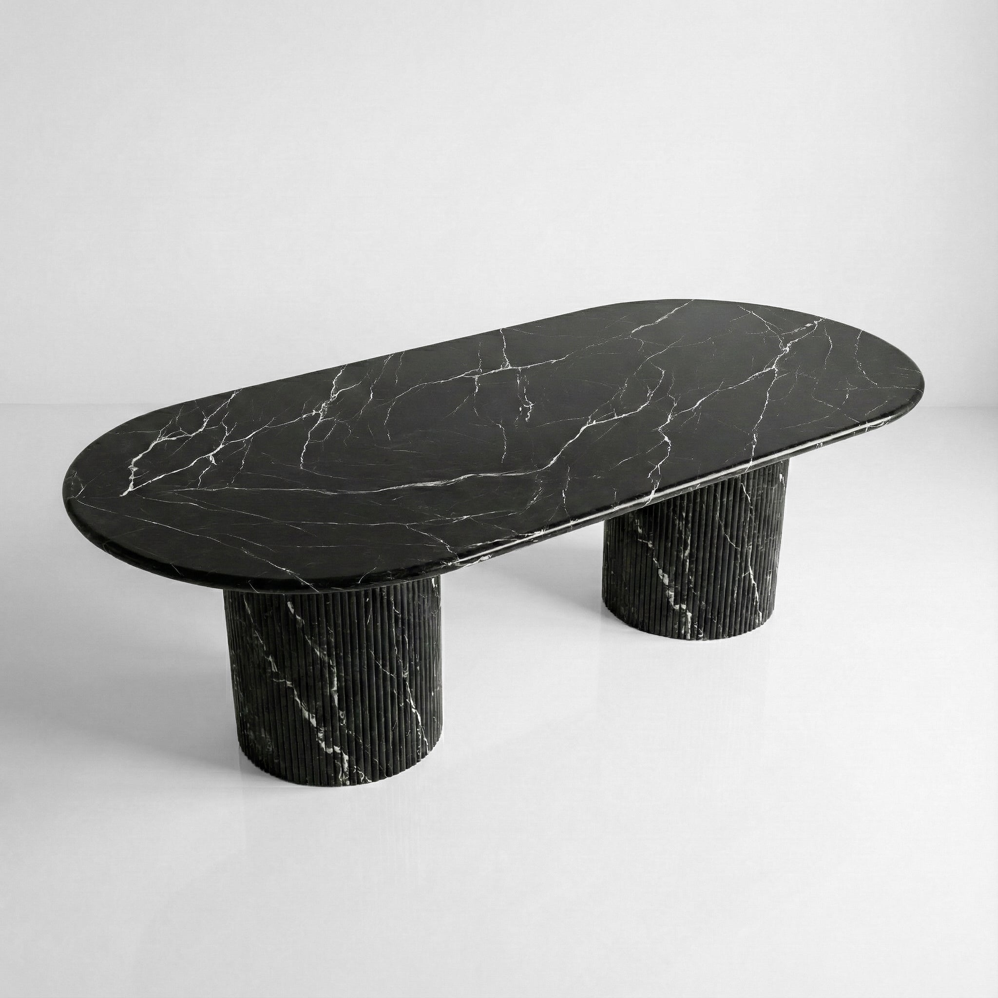 High-angle view of a large oval Nero Marquina dining table, showcasing the polished black natural stone surface with striking white lightning veining.