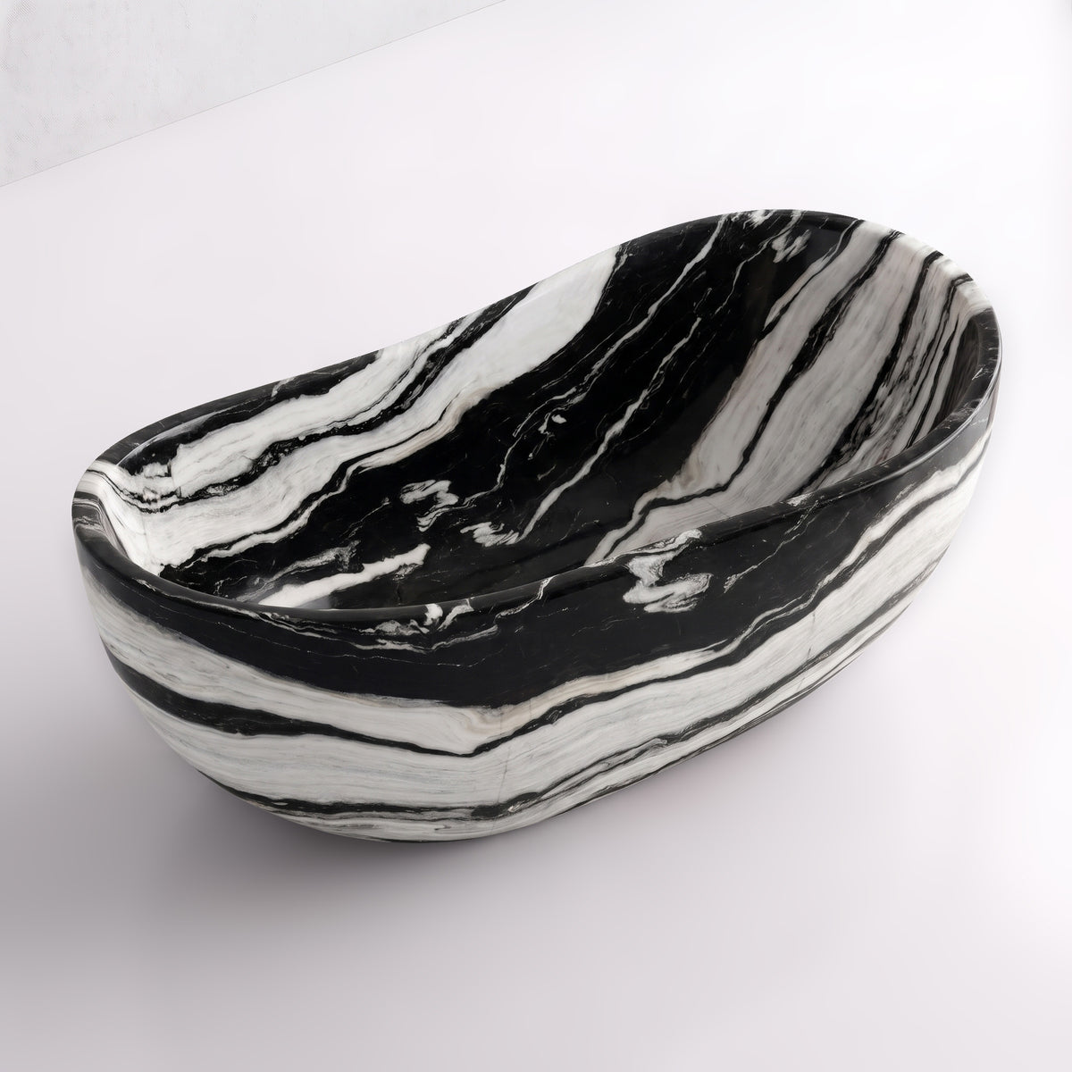 Elevated three-quarter perspective view of the Panda White marble wave soaking tub, highlighting the asymmetrical undulating rim, seamless solid-carved interior, and dramatic high-contrast monochrome banding flowing across the stone.