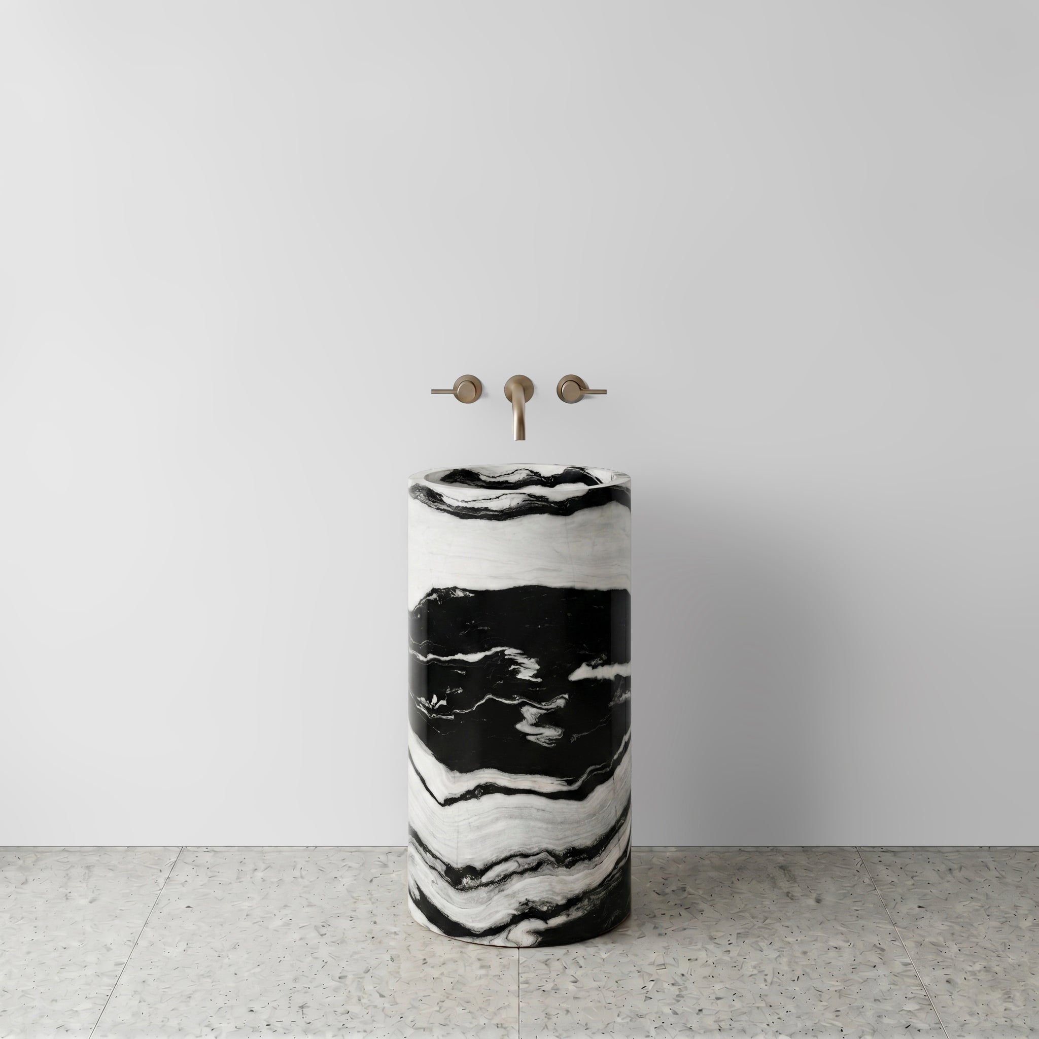 Front view of a monolithic Panda White marble cylinder pedestal sink showcasing bold black and white banding with wall-mounted bronze tapware.