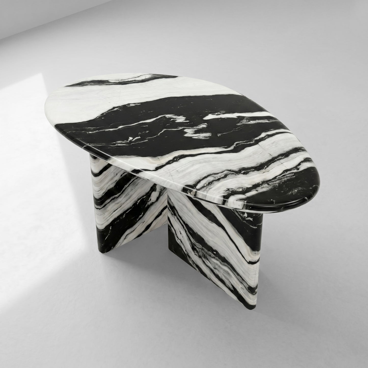 High-angle view of a contemporary pebble-shaped coffee table crafted from Panda White marble, emphasizing its unique organic silhouette and striking natural stone artistry.