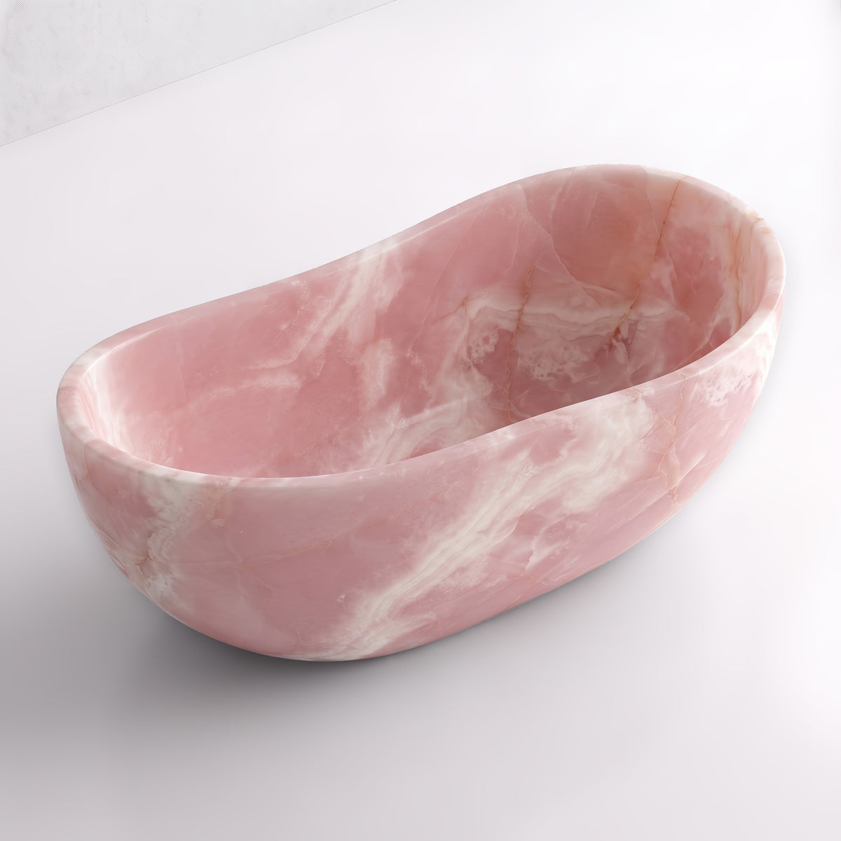 Elevated three-quarter perspective view of the Pink Onyx wave soaking tub, highlighting the asymmetrical undulating rim, seamless solid-carved interior, and delicate rose-quartz mineral strata.