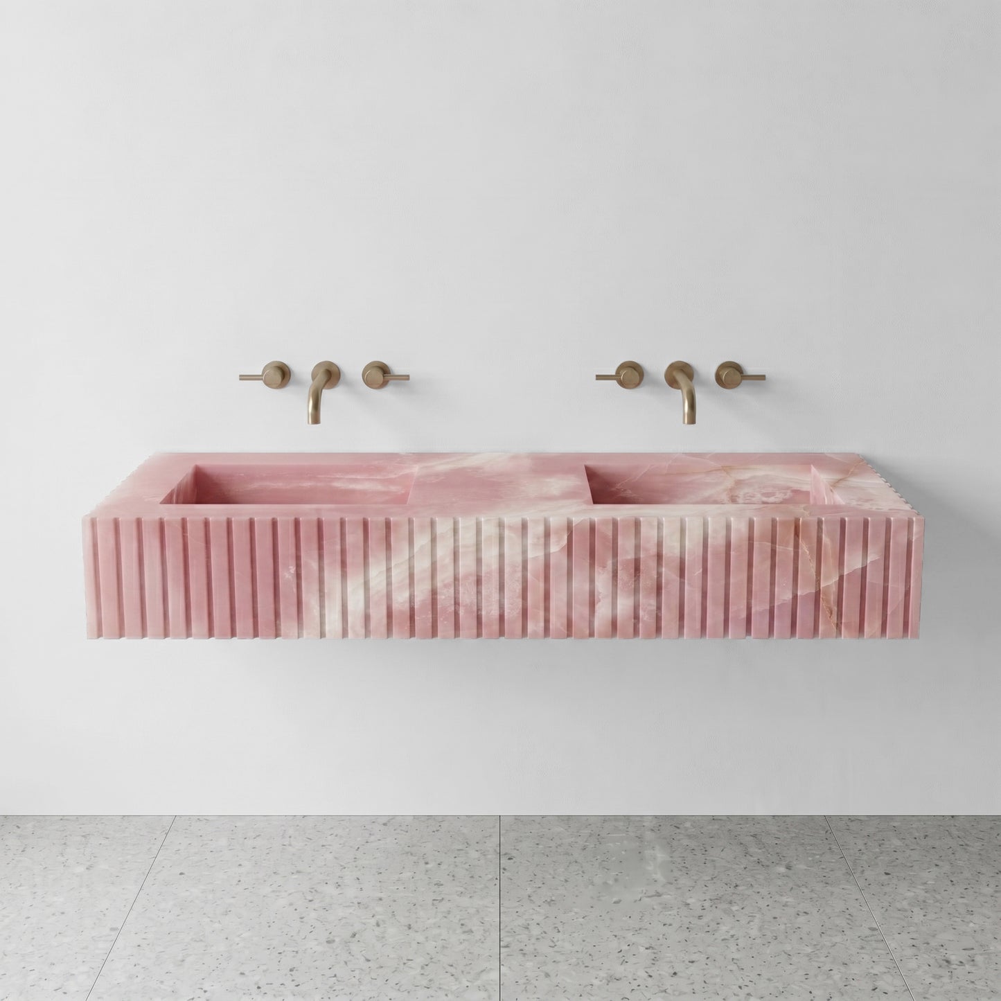 Front profile of a floating double vanity crafted from Pink Onyx, displaying soft rose quartz hues and vertical ribbed detailing.