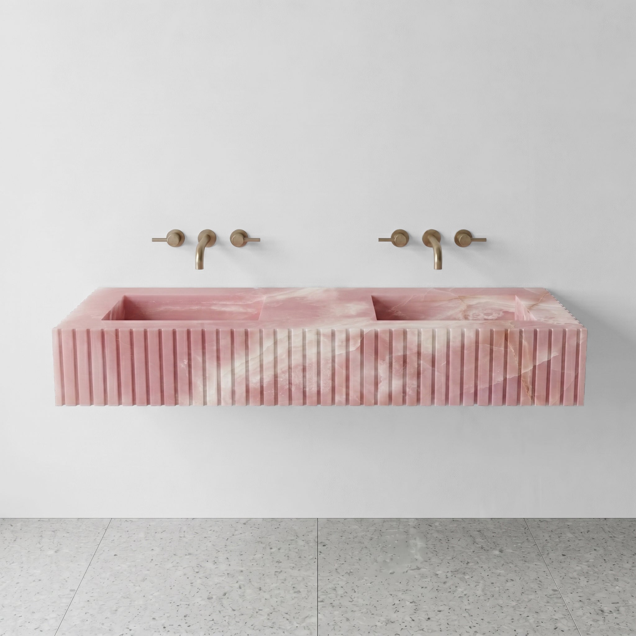 Front profile of a floating double vanity crafted from Pink Onyx, displaying soft rose quartz hues and vertical ribbed detailing.