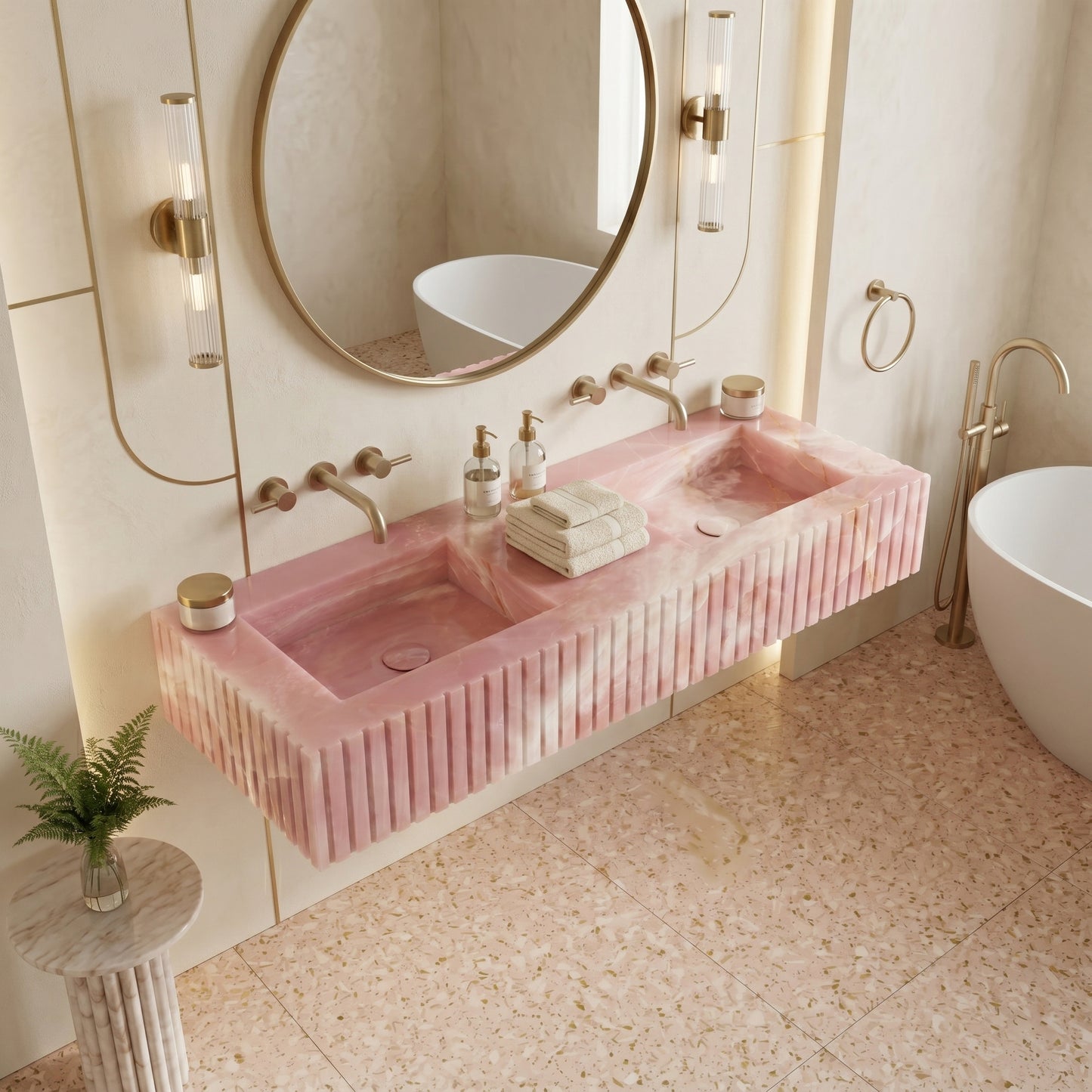 Romantic luxury bathroom featuring a backlit Pink Onyx fluted sink, paired with gold arched mirrors and warm wall sconces.