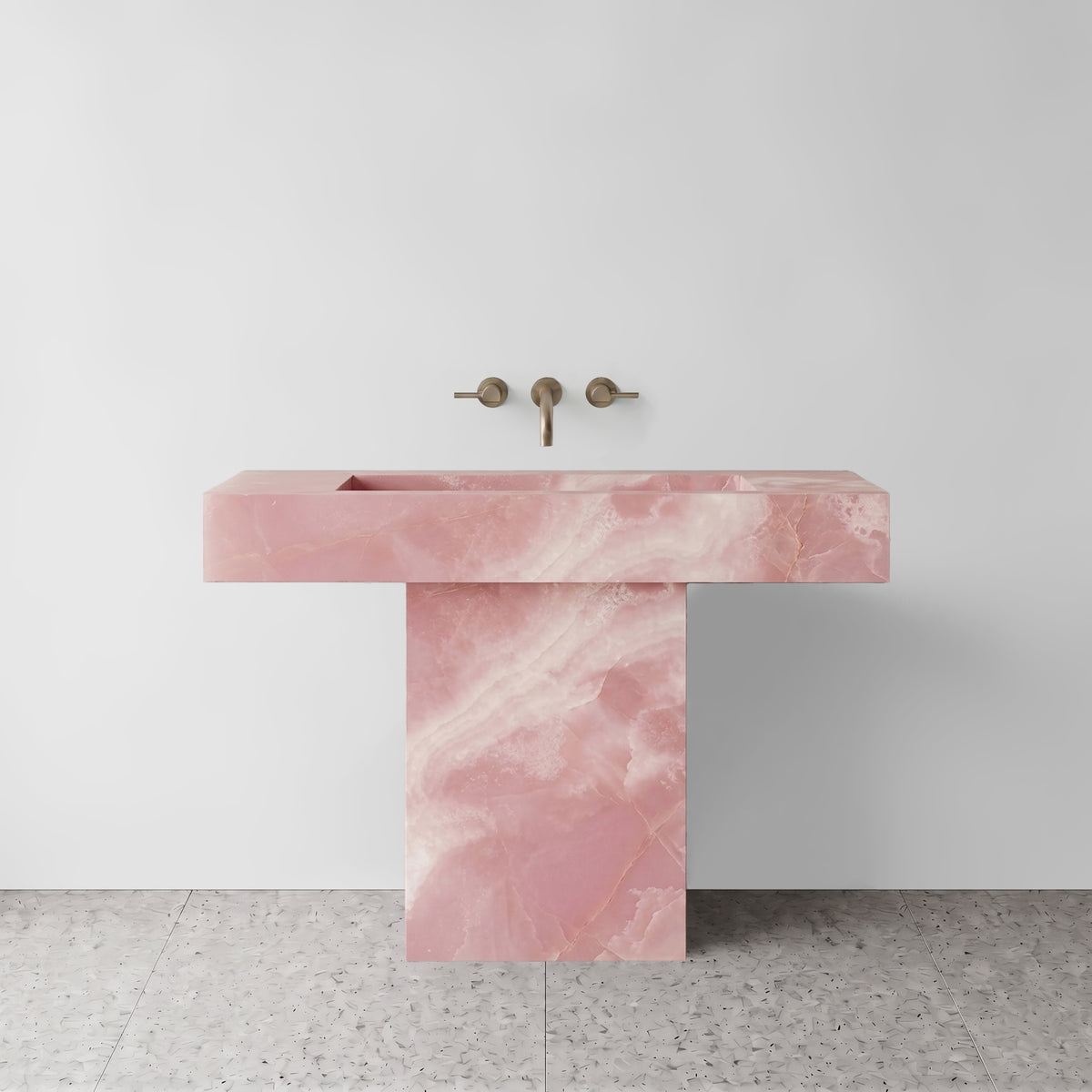 Front view of the blush Pink Onyx T-shape pedestal sink showing delicate crystalline banding across the cantilevered basin and hollow base plinth.