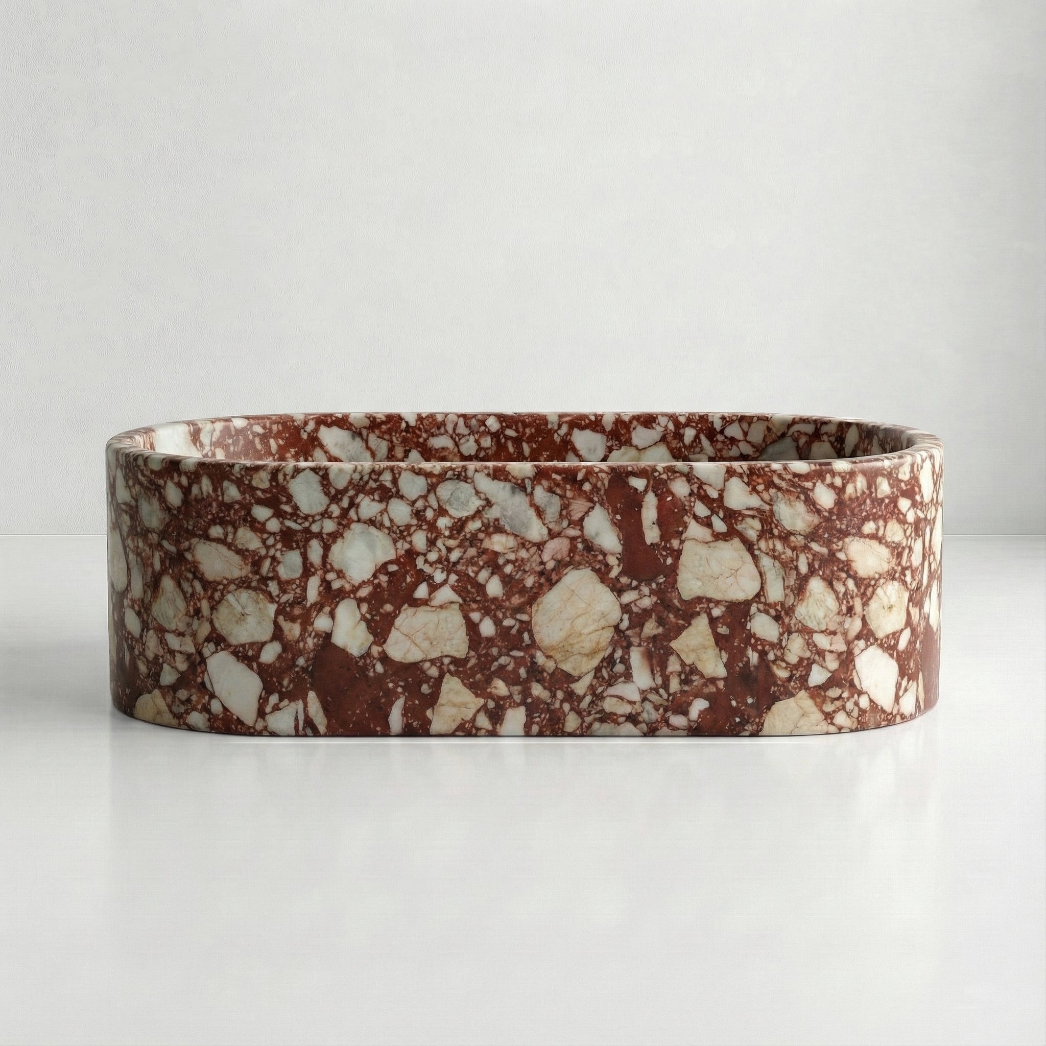 Front elevation of a solid Red Bulgari marble bathtub displaying a vibrant mosaic of deep red and white mineral fragments.