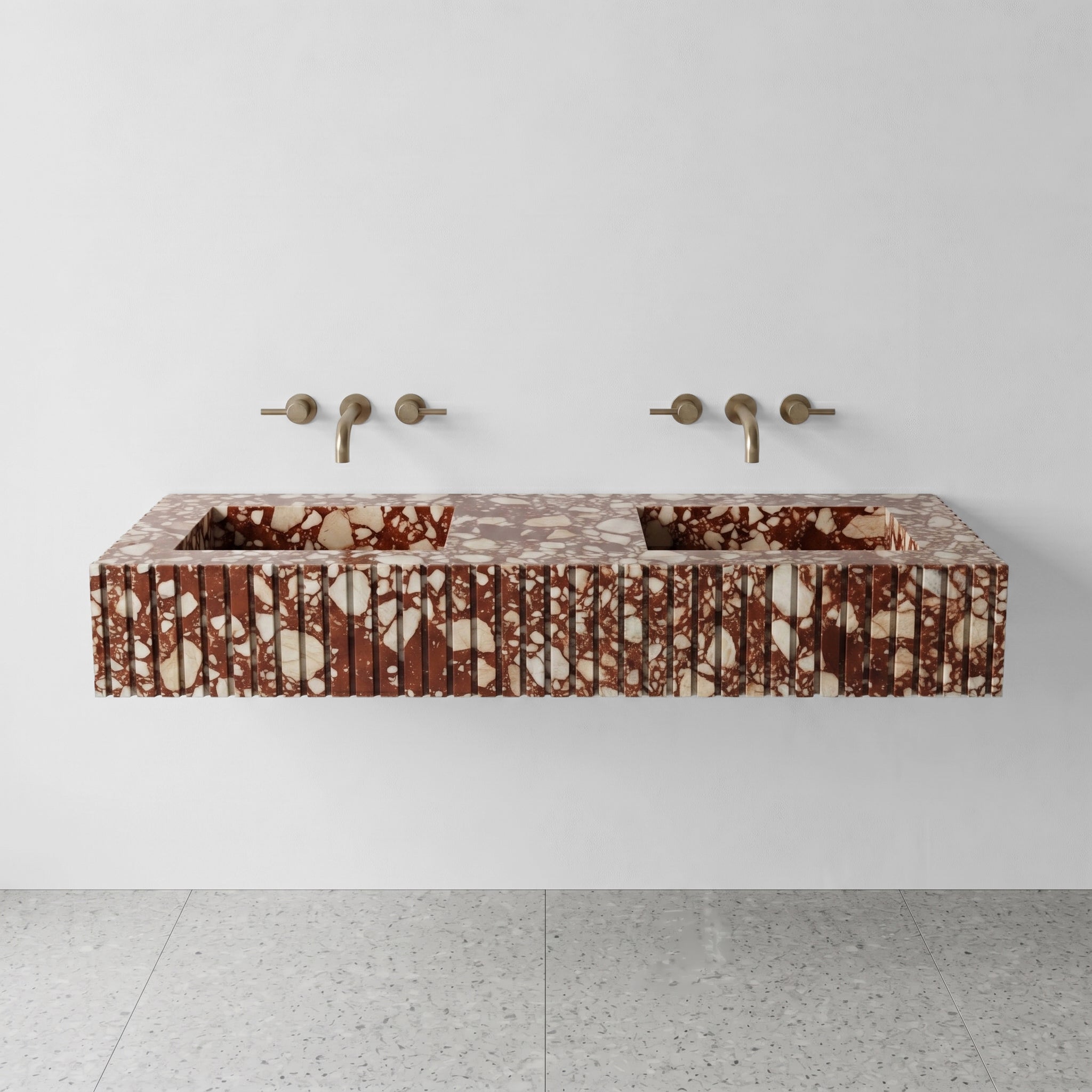 Front profile of a floating double vanity crafted from Red Bulgari marble, displaying a custom fluted apron and bold mosaic-like burgundy and white stone patterns.