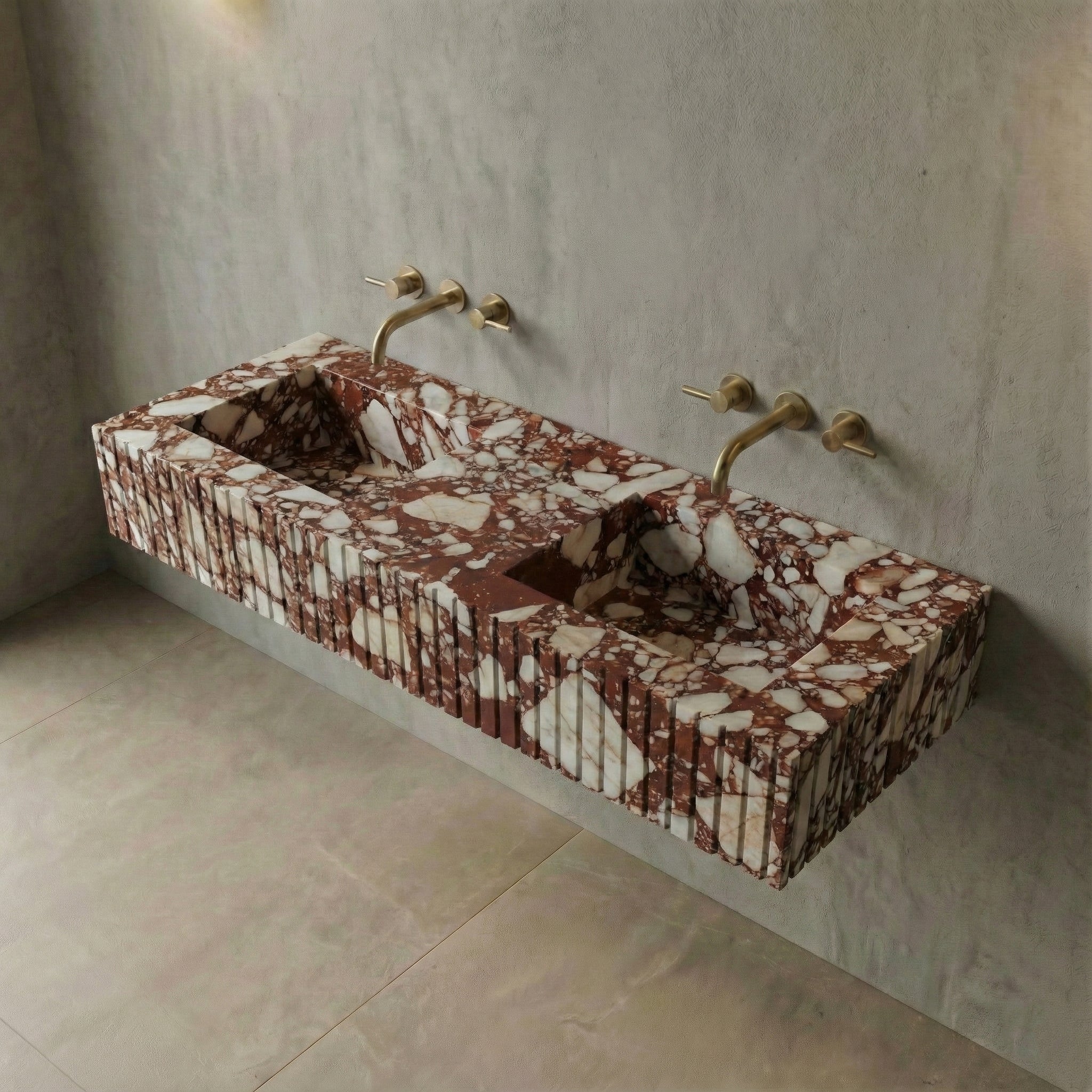 High-angle view of a wall-mounted Red Bulgari stone sink featuring dual integrated basins and the stone's signature high-contrast brecciated texture.