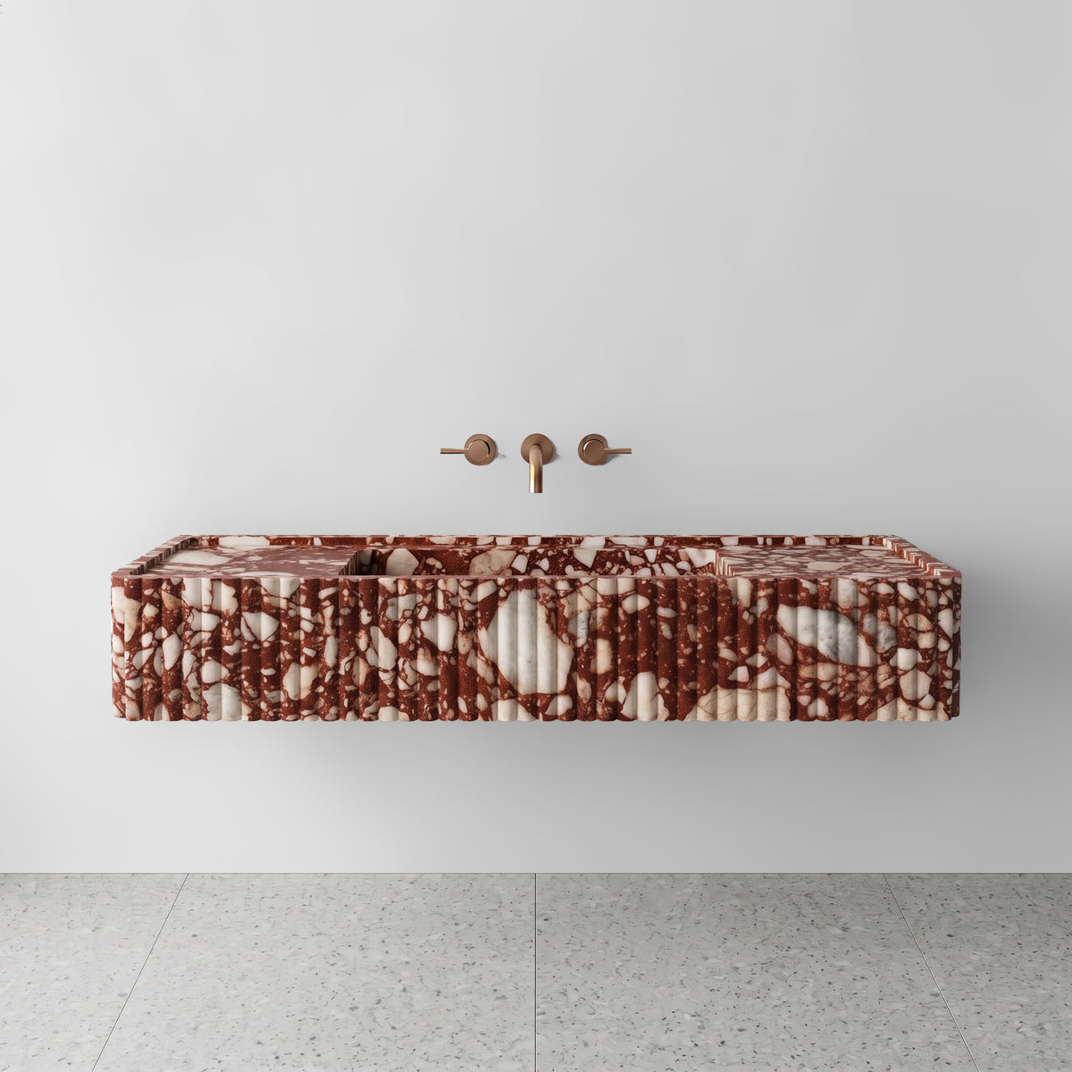 Front view of the Red Bulgari marble fluted monolith sink showing rich crimson breccia and white calcite veining across the vertical convex ribbed apron and wall-mounted brushed bronze faucet.