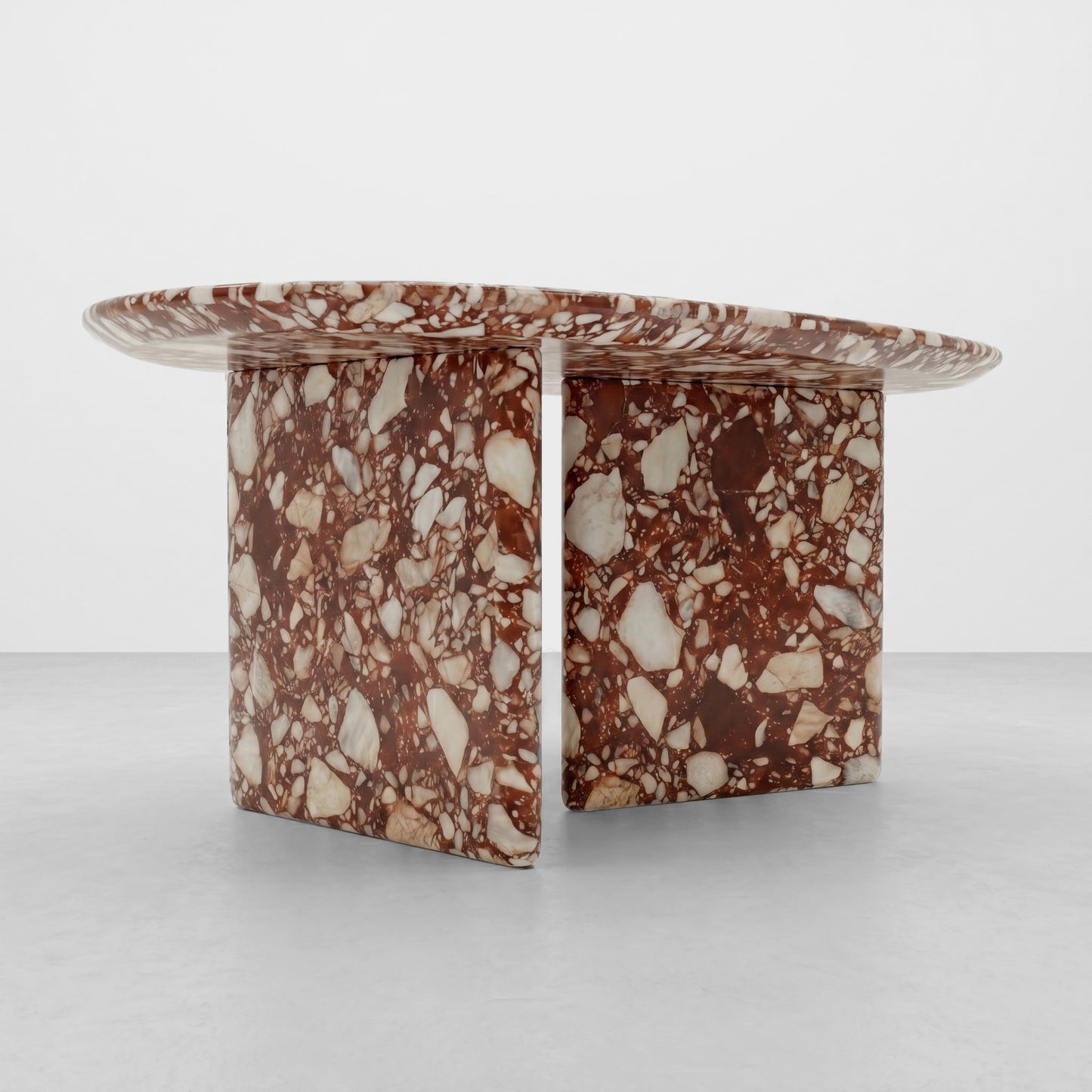 Close-up detail of the polished edge and dramatic red and cream brecciated texture of a Red Bulgari marble coffee table, showcasing high-end stone craftsmanship.