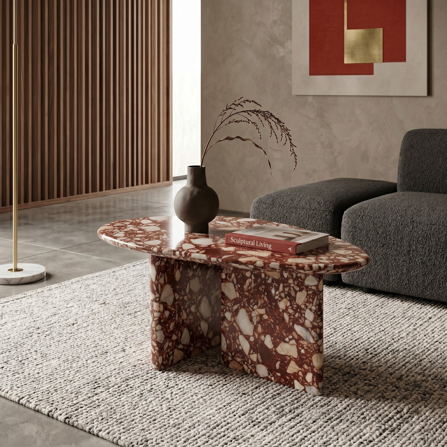 Contemporary living room featuring an organic Red Bulgari marble coffee table styled with a ceramic vase on a textured rug, paired with a modern grey sofa.