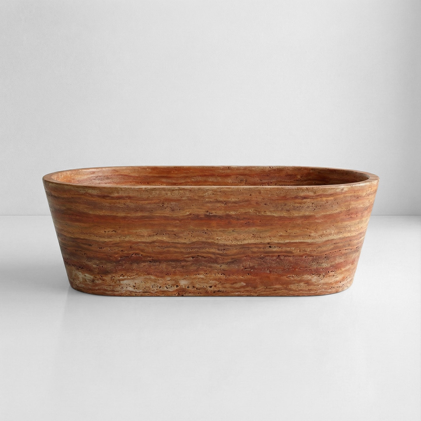 Front profile view of a statement Red Travertine bathtub displaying bold horizontal striations in deep orange and earthy red hues.