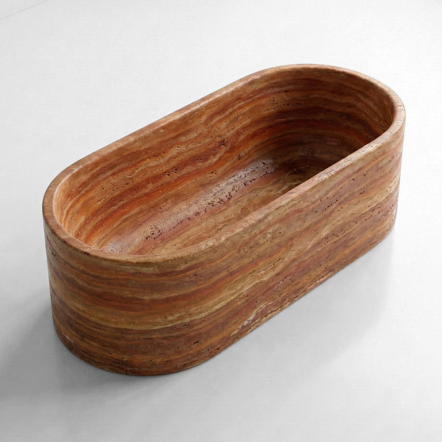 sometric side view of an oval Red Travertine stone tub with deep earth tones and a honed natural finish.