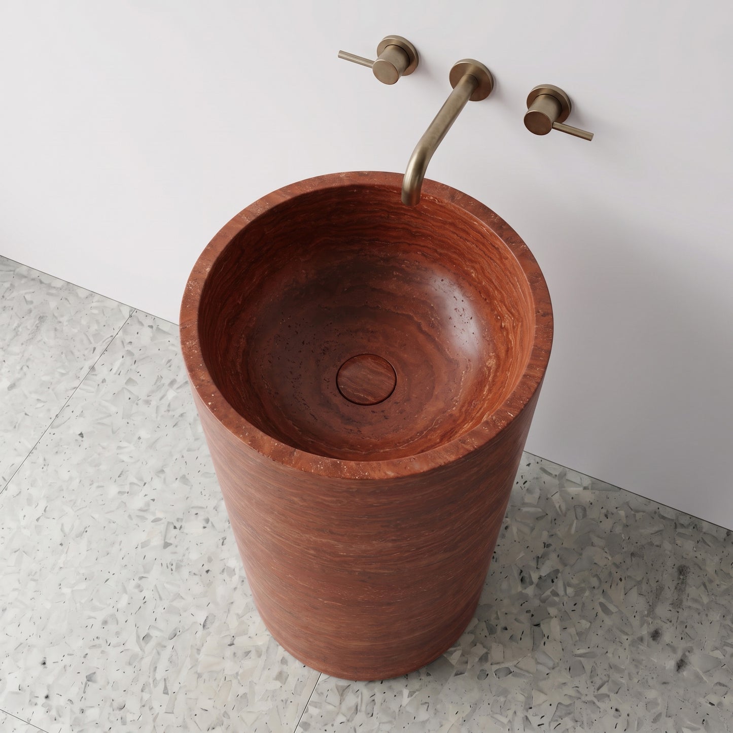 High-angle top view of a Red Travertine cylindrical stone sink highlighting natural porous strata texture and matching integrated carved drain cap.