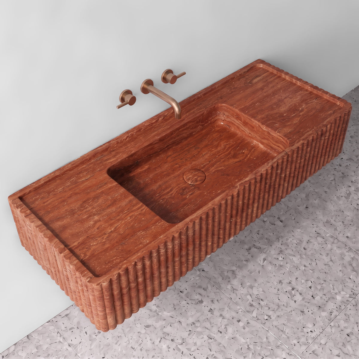 Elevated three-quarter angle of the Red Travertine fluted monolith sink showing the integrated trough basin, matching stone drain cover, raised perimeter rim, and reeded profile edges.