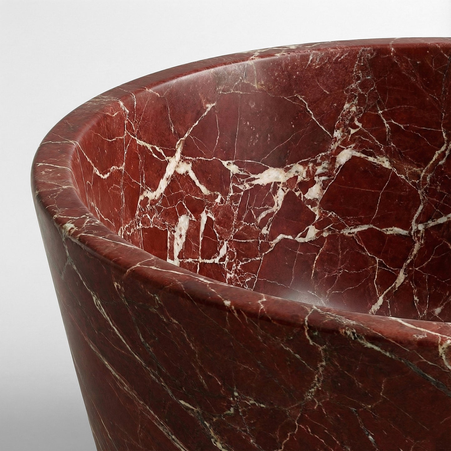 Close-up detail of a Rosso Levanto bathtub rim showing intricate white brecciated veins contrasting against a dark cherry red natural stone background.