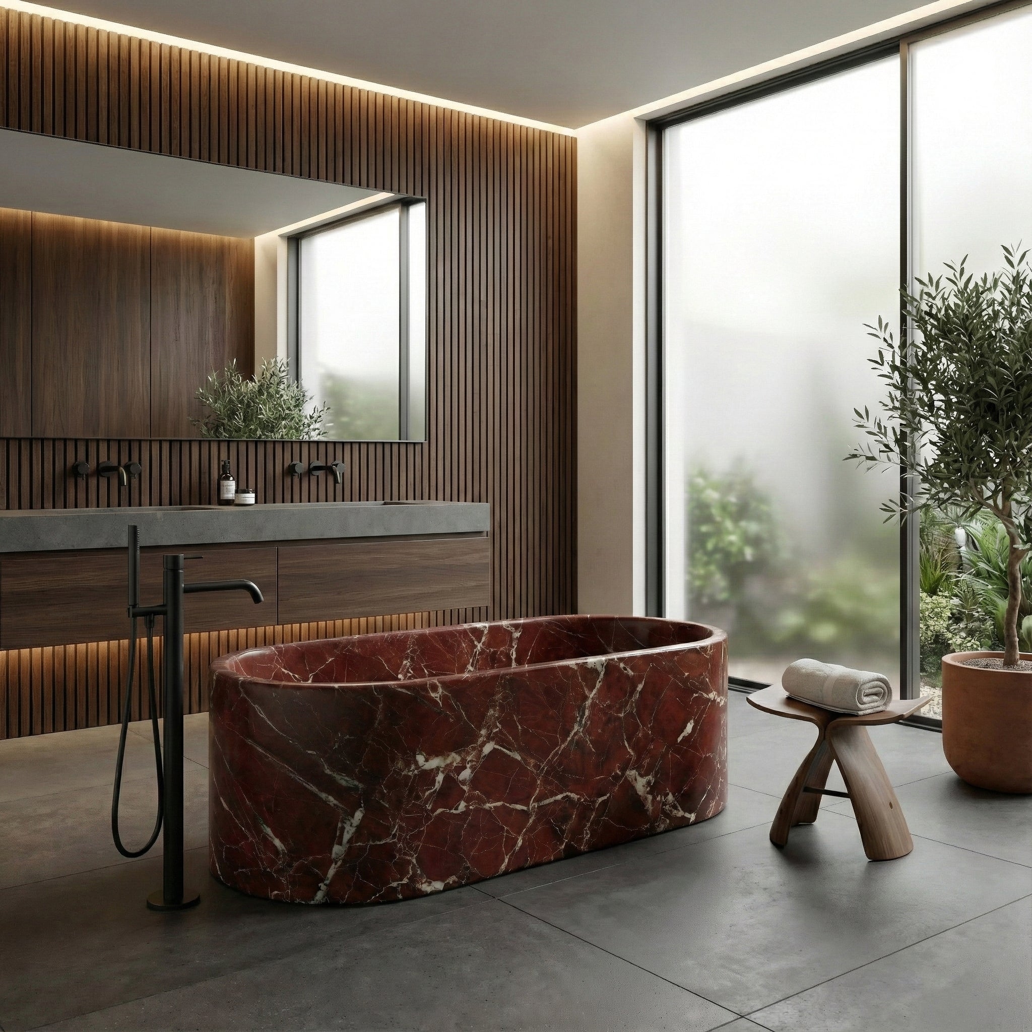 Modern luxury bathroom featuring a Rosso Levanto marble bathtub, dark wood slat wall, grey stone flooring, and a freestanding matte black tub filler.
