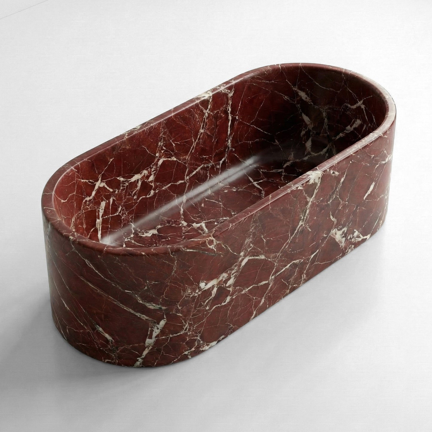 Angled isometric view of a freestanding Rosso Levanto marble bathtub showing the deep burgundy red stone and intricate white calcite veining.