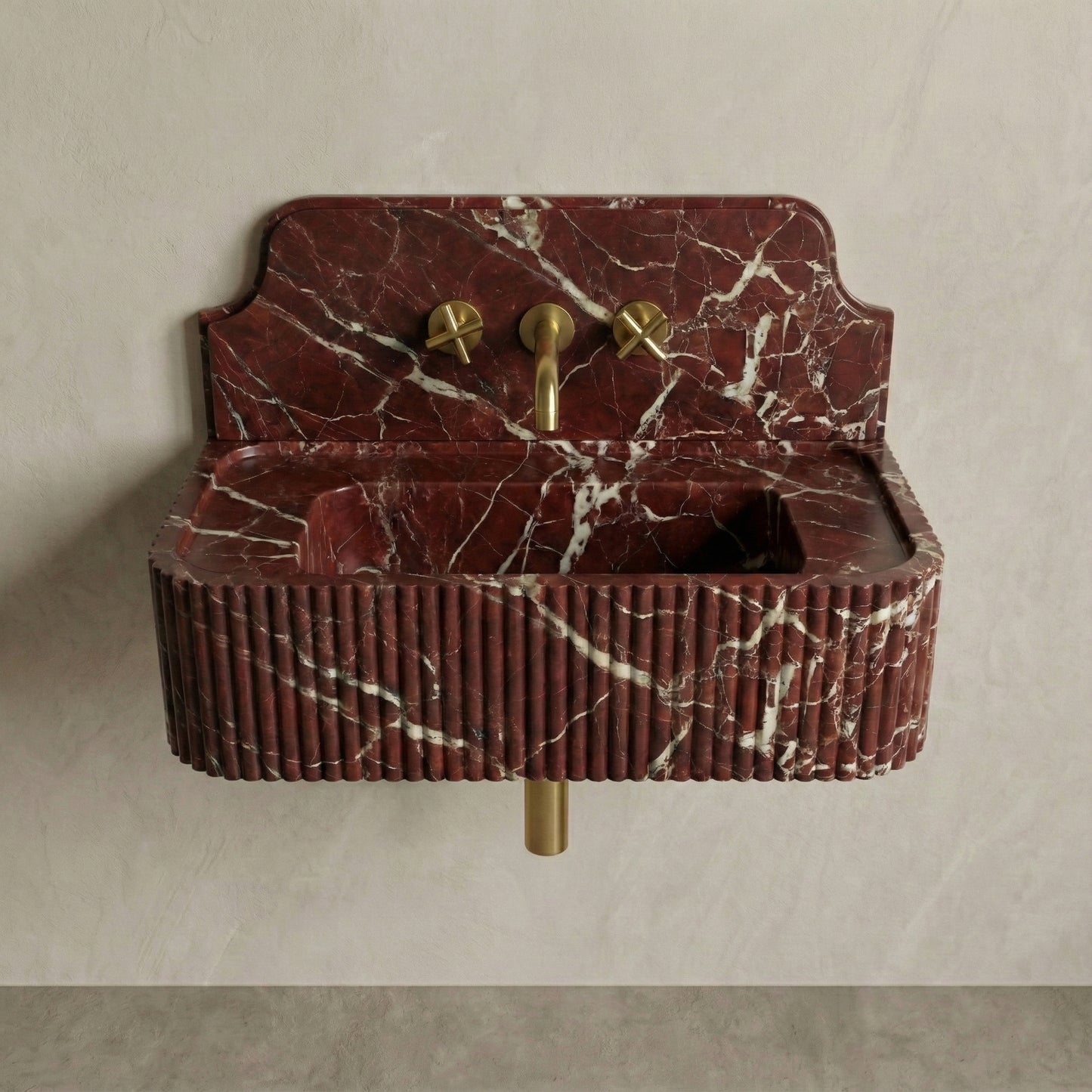 Front profile of a wall-mounted Rosso Levanto marble basin with a decorative high backsplash, deep burgundy red stone, and vertical ribbed detailing.