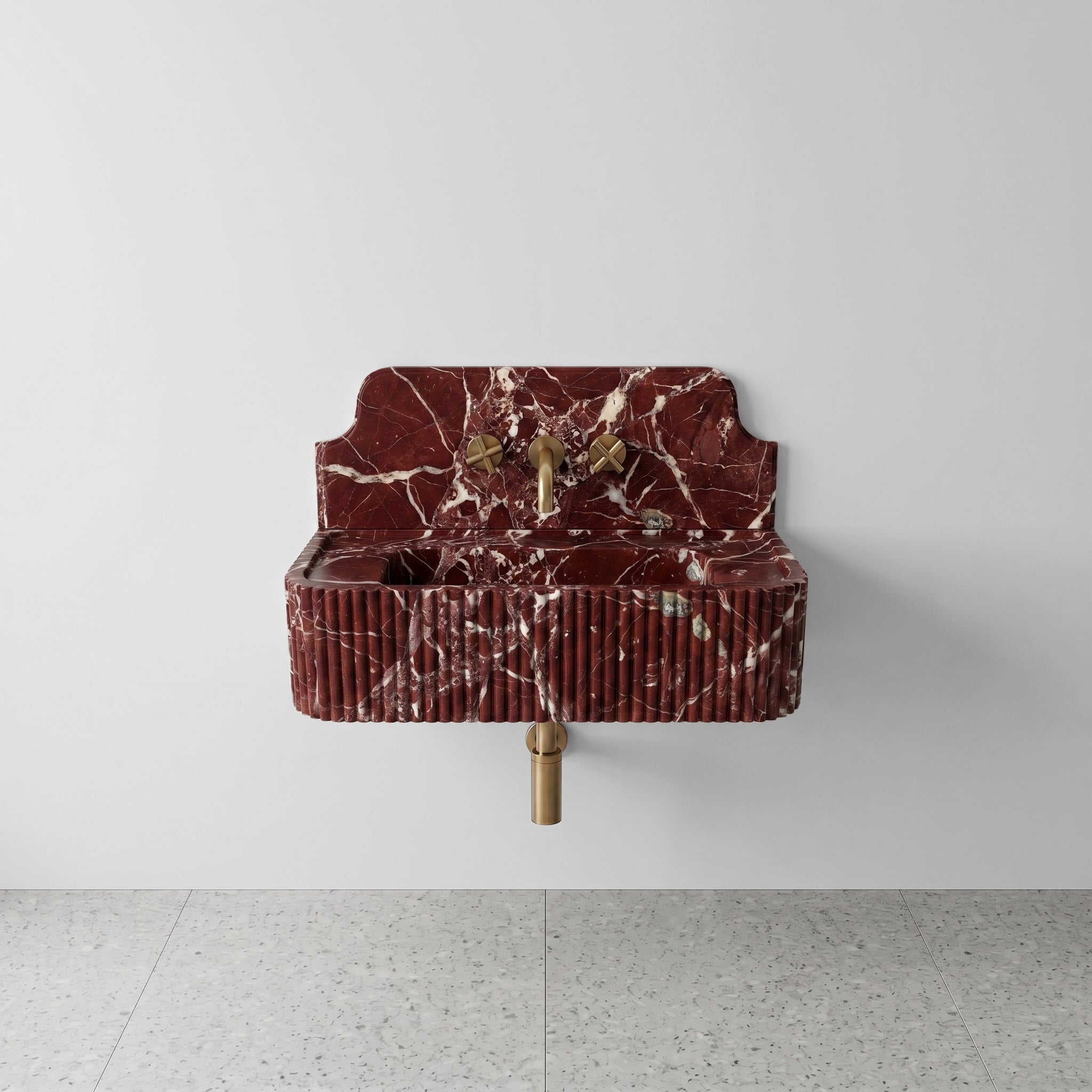 Front profile of a wall-mounted Rosso Levanto marble basin with a decorative high backsplash, deep burgundy red stone, and vertical ribbed detailing.