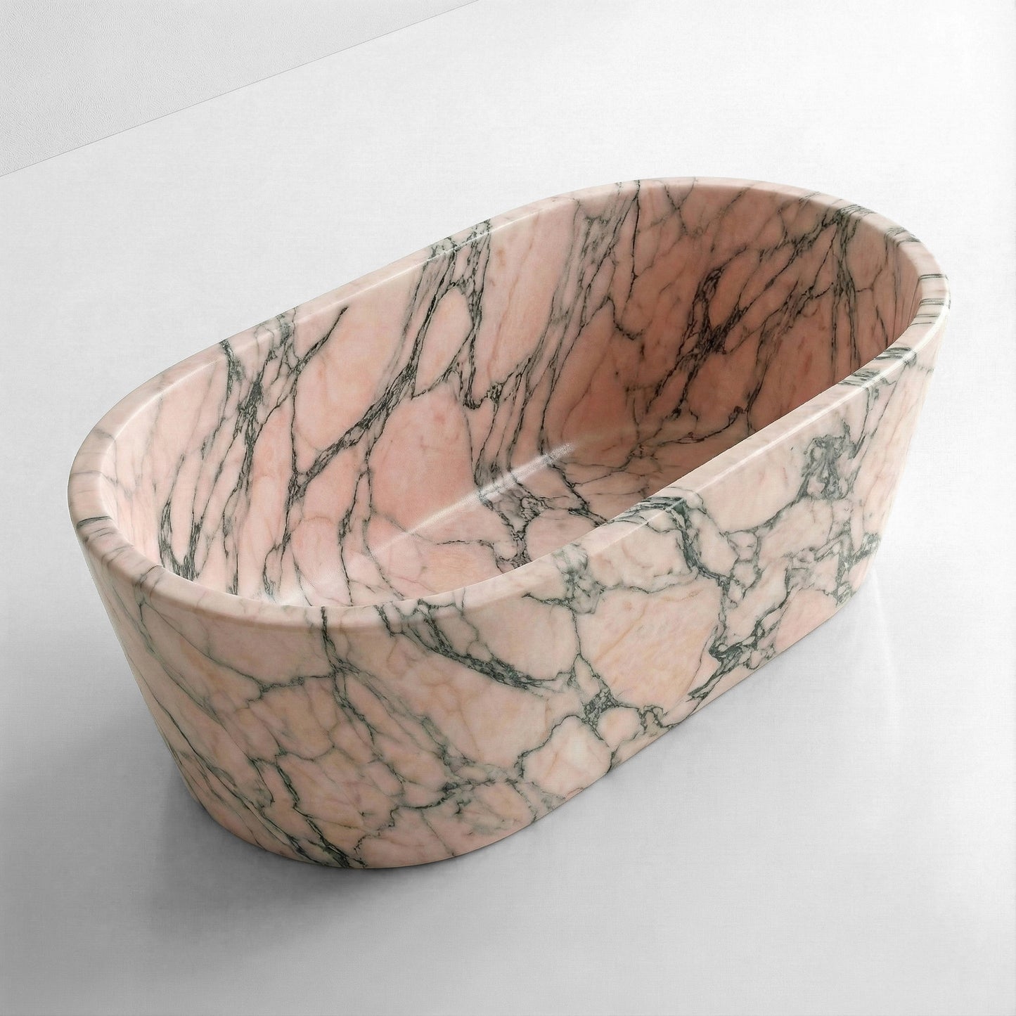 High-angle view of an oval pink marble bathtub, showcasing the polished Rosso Portogallo surface and deep, seamless stone interior.