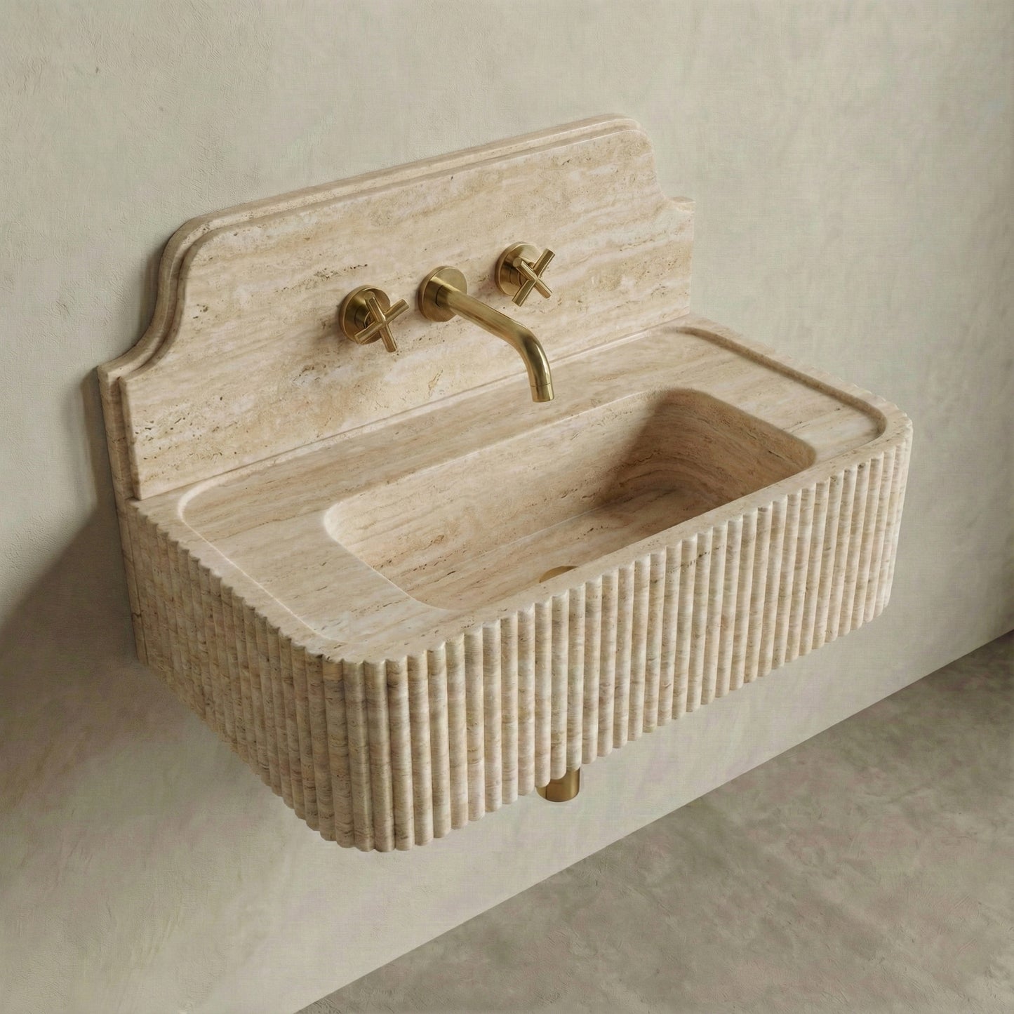 High-angle side view of a vintage-inspired Travertine Romano sink, showcasing the curved stone backsplash, fluted apron, and natural beige vein-cut texture.