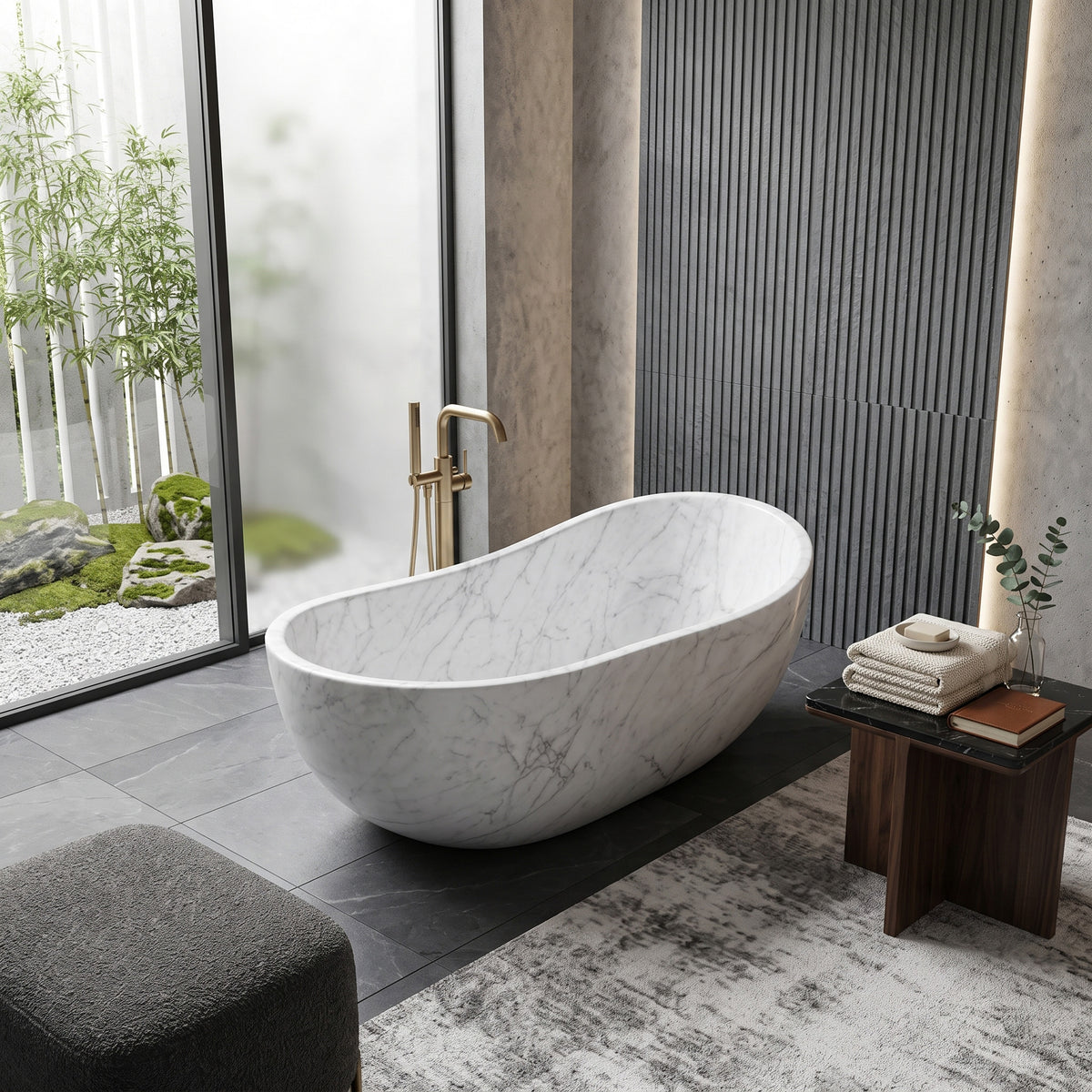 Minimalist luxury bathroom retreat featuring the freestanding White Carrara marble wave bathtub paired with a floor-mounted brushed gold tub filler, vertical fluted dark grey wall cladding with backlighting, dark slate floor tiles, a timber accent table, and floor-to-ceiling glass overlooking a tranquil bamboo rock garden.