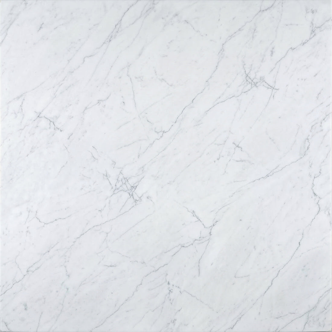 Classic White Carrara marble slab featuring soft, delicate grey veining on a light background for luxury countertops and flooring.