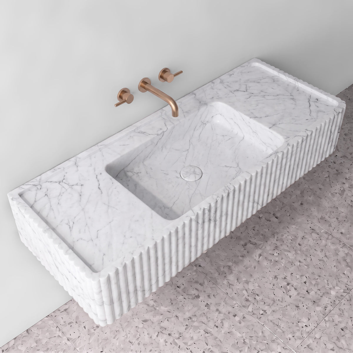 Elevated three-quarter angle of the White Carrara fluted monolith sink showing the integrated trough basin, matching stone drain cover, raised perimeter rim, and ribbed profile edges.